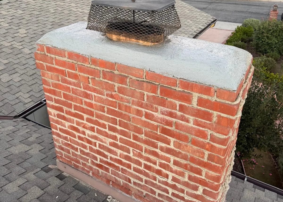 Rebuilt brick chimney with new concrete crown and chimney cap on a California home