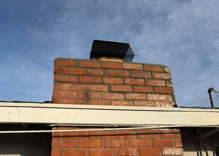 Rebuilt brick chimney stack above the roofline of a California home